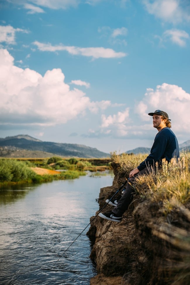 Un garçon pêchant dans ce qui semble être une rivière.